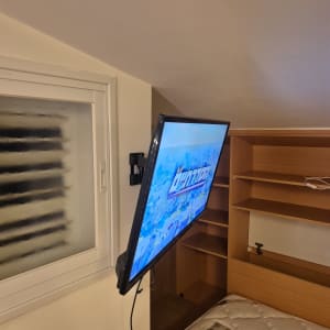 טלוויזיה מותקנת על קיר בחדר שינה