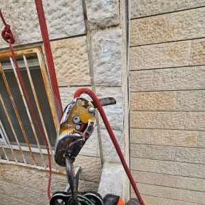 חבל אדום ומכשיר טיפוס על קיר אבן