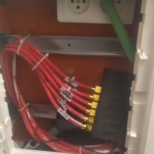 כבלים אדומים מחוברים ללוח חשמל עם תוויות