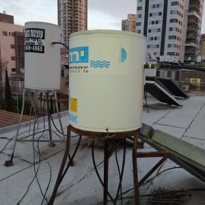 דודי שמש על גג בניין עם רקע עירוני