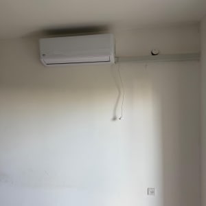 מזגן מותקן על קיר לבן ללא אנשים או טקסט