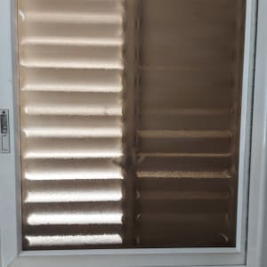 חלון זכוכית עם תריסים חצי פתוחים