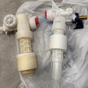 שני חלקי פלסטיק לבנים עם ברזים אדומים