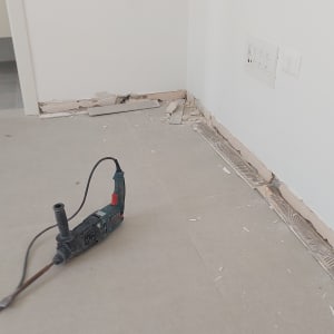 כלי עבודה על רצפה ליד קיר עם שקעי חשמל