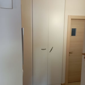 ארון לבן עם דלתות סגורות וידיות שחורות