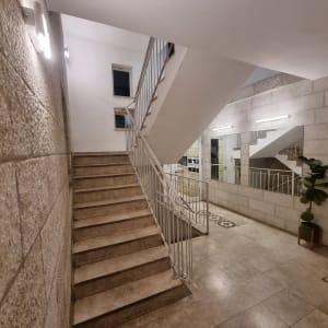 גרם מדרגות עם קירות אבן ותאורה חזקה