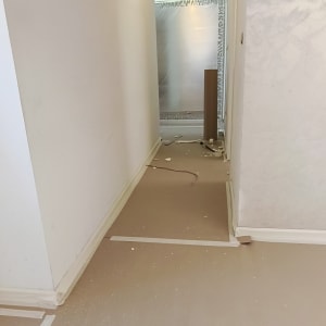 מסדרון עם קירות צבועים וציוד צביעה על הרצפה