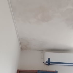 תקרה צבועה עם סימני תיקון וארונות מכוסים בנייר דבק