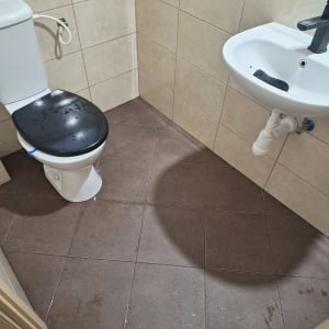 שירותים וכיור עם רצפה רטובה