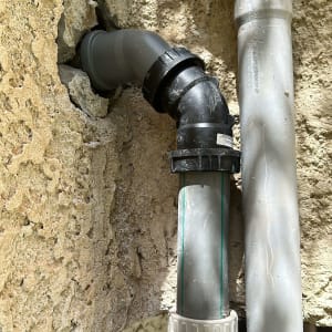 צינורות פלסטיק מחוברים לקיר אבן