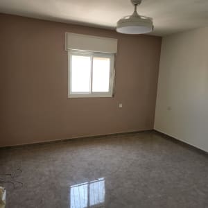 חדר ריק עם קיר צבוע בצבע בז