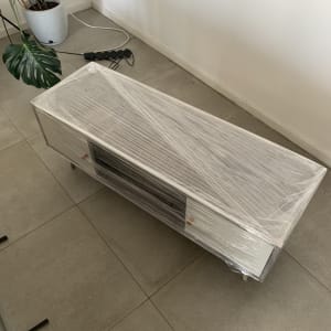 שידה עטופה בניילון נצמד על רצפה אפורה