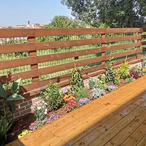 גינה עם פרחים וגדר עץ