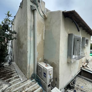 יחידת מיזוג אוויר מותקנת על קיר חיצוני עם צינורות