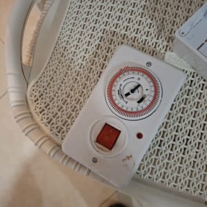 טיימר חשמלי עם מתג הפעלה אדום על שולחן