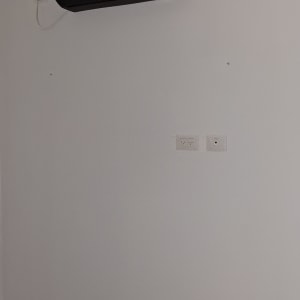 חדר עם מזגן ומאוורר תקרה מעל מיטה
