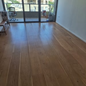רצפת פרקט עץ טבעי נקייה ומבריקה בדירה לאחר טיפול פוליש