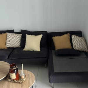 ספה אפורה עם כריות צבעוניות ושולחן עץ עם נרות