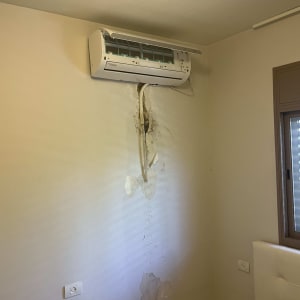 מזגן מותקן על קיר עם סימני רטיבות