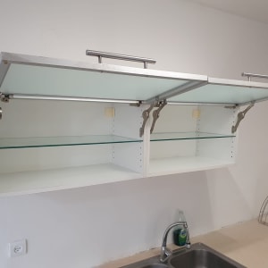 ארון מטבח פתוח עם מדפים ריקים וסבון כלים ליד כיור