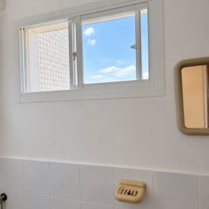חלון קיר לבן עם אריחים ומראה