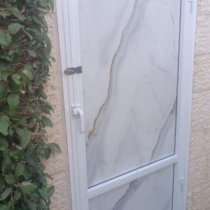דלת אלומיניום לבנה עם ידית ומנעול