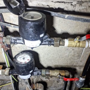 שני מדי מים עם ברזים אדומים וצינורות מתכת