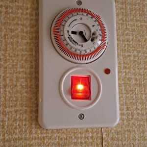 שעון טיימר עם מתג מואר על קיר