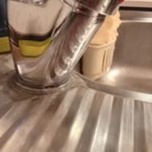 ברז נירוסטה בכיור מטבח עם מים זורמים