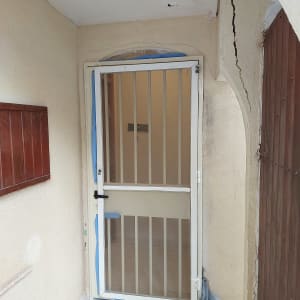 דלת מתכת עם סורגים ומסגרת לבנה