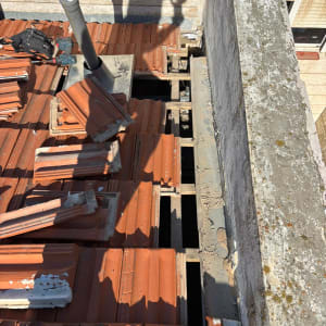 רעפים כתומים על גג עם צינור מתכת