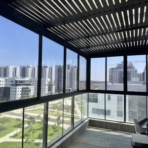 מרפסת סגורה עם חלונות זכוכית ונוף עירוני