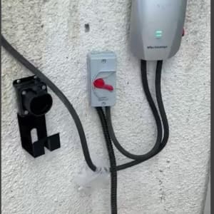 עמדת טעינה חשמלית עם כבלים ומתג על קיר