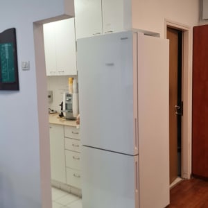 מטבח עם מקרר לבן וארונות לבנים