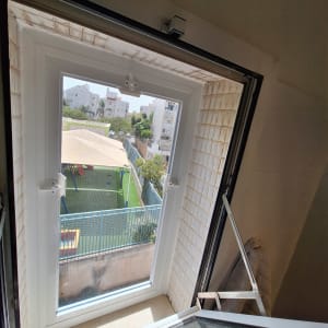 חלון אלומיניום פתוח עם נוף חיצוני