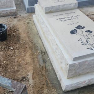 מצבות בבית קברות עם כיתוב בעברית ועיטורים.