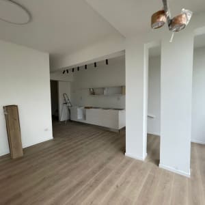 קירות גבס לבנים בחדר ריק עם רצפת עץ