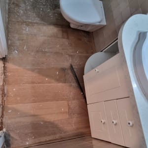 חדר אמבטיה עם רצפה חדשה וכלים סניטריים מותקנים