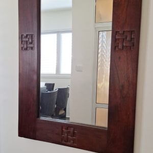 מראה עם מסגרת עץ על קיר לבן