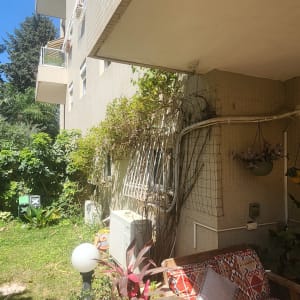 מרפסת עם צמחים וריהוט גן ליד בניין מגורים