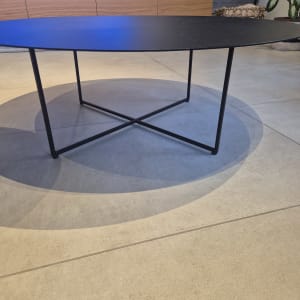 שולחן עגול עם רגלי מתכת על רצפת אריחים