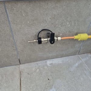 שסתום גז מחובר לצינור כתום על קיר