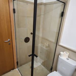 מקלחון זכוכית עם מסגרת מתכת שחורה