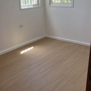 חדר עם רצפת פרקט חדשה ושני חלונות