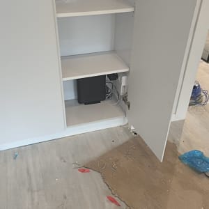 ארון פתוח עם ציוד תקשורת וחוטים על הרצפה