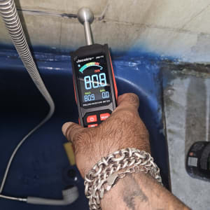 מד לחות דיגיטלי נוגע בקיר לבדיקה