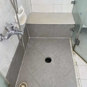 מקלחת עם אריחים אפורים וברז מתכת