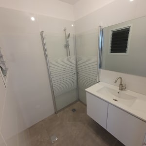 חדר אמבטיה עם מקלחון, כיור וברז