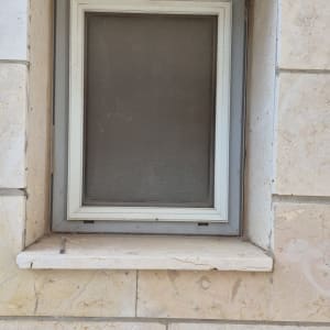 חלון עם מסגרת אלומיניום בקיר אבן