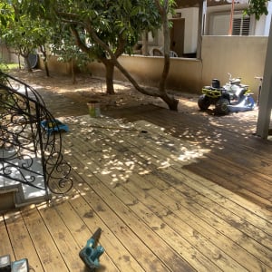 דק עץ עם כלי עבודה וצעצועים בגינה